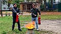 Zwei Projektron-Mitarbeiter löschen ein Feuer im Rahmen der Brandschutzhelferausbildung. Zwei Mitarbeiter löschen ein Feuer während einer praktischen Übung der Brandschutzhelferausbildung.