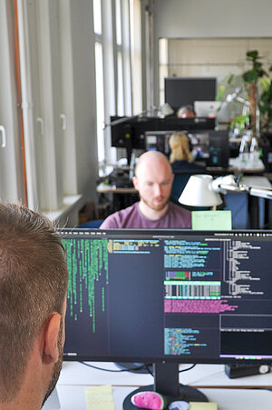 Employees of Das Büro am Draht work on software development.