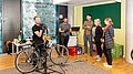 Zwei Mitarbeiterinnen der Deutschen Bahn besuchen unseren jährlichen Fahrradcheck für die DB-Homestory nach Gewinn der Climate Mobility Challenge. Zwei DB-Mitarbeiterinnen stehen beim jährlichen Fahrradcheck von Projektron und besuchen das Team für eine Homestory.