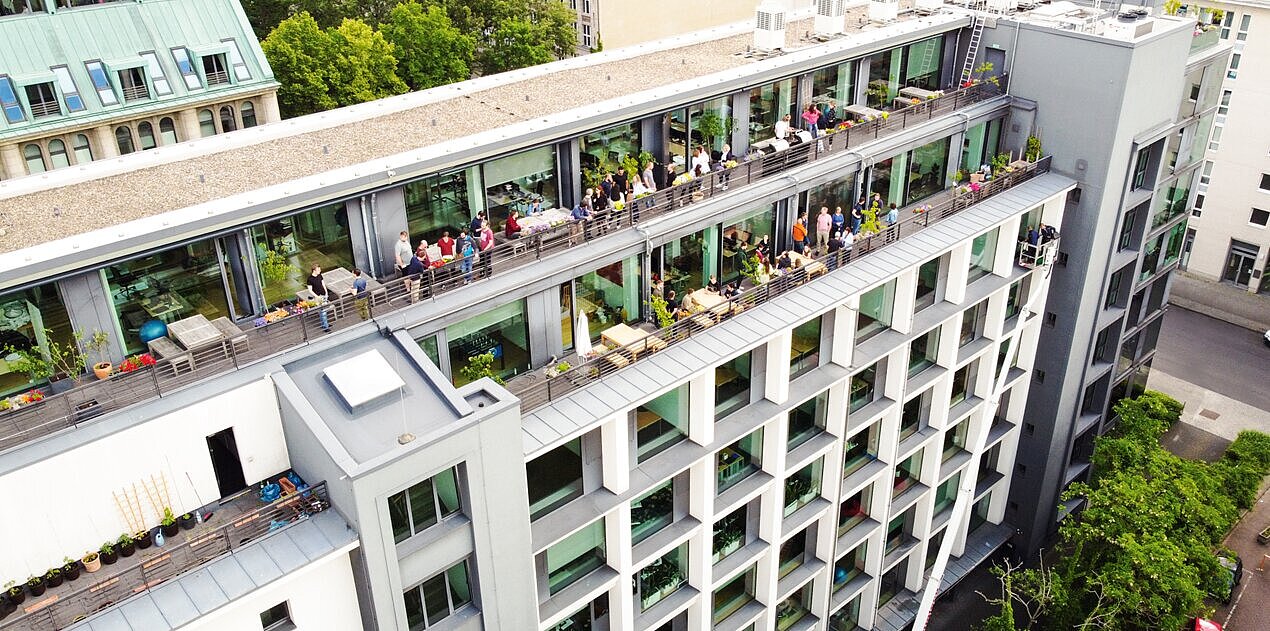  Siège social moderne de Projektron à Berlin-Mitte, avec des bureaux baignés de lumière et des postes de travail ergonomiques.