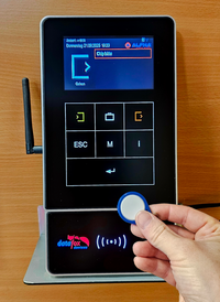 An employee records his attendance at Alfha’s Datafox terminal using a personal Hitag1 RFID chip. The chip ID is stored as an additional attribute in BCS for identification. Bookings are transmitted live to BCS, with immediate feedback at the terminal. Employee at Alfha recording attendance with Hitag1 RFID chip at Datafox terminal, live connected to BCS with instant feedback.